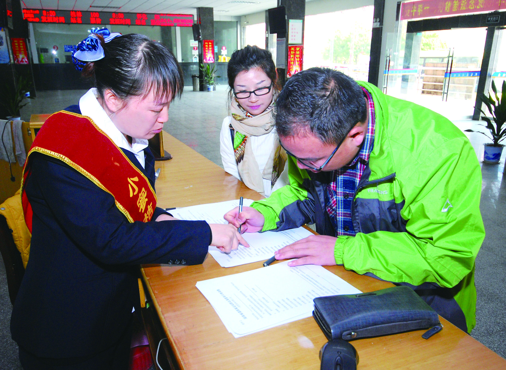 圖為洞口汽車總站站務(wù)人員在熱心為旅客服務(wù)。