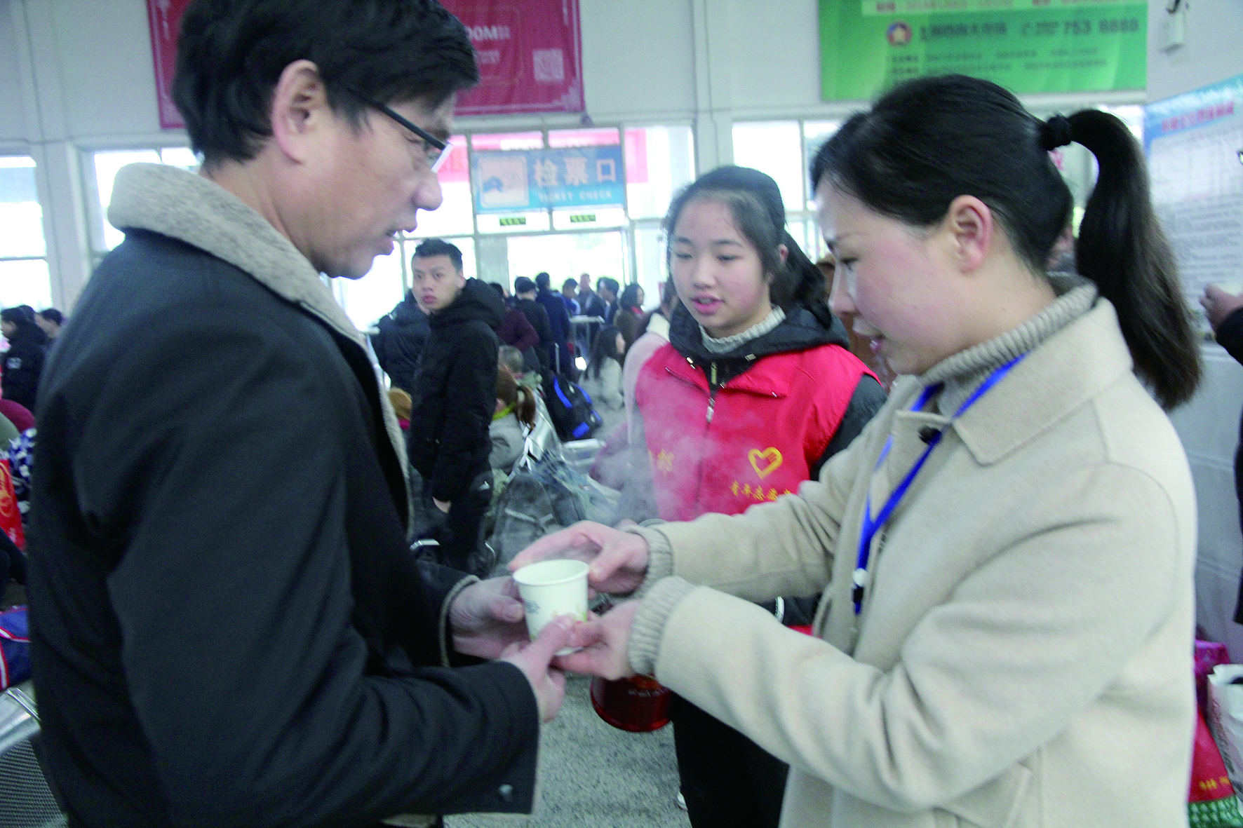 母女服務春運 2月13日，記者在新邵分公司汽車站看到，該分公司安全科副科長李喜梅與其在新邵一中初中部1701班就讀女兒劉嘉怡在車站擔當志愿者。李喜梅在候車室耐心為旅客釋疑解惑，劉嘉怡為旅客遞上一杯杯熱茶，有時母女也相互合作，其樂融融。 祖冠 攝影報道